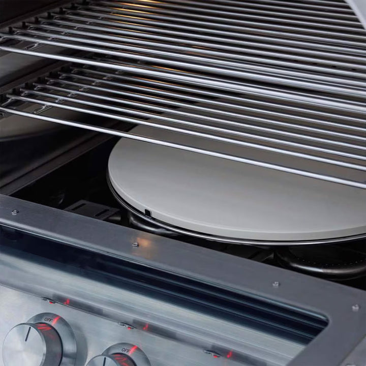 Close-up of a pizza stone inside an oven with metal racks.