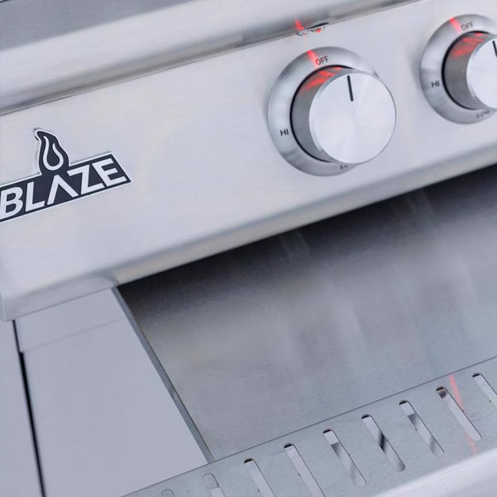 Close-up of a Blaze grill with control knobs and logo.